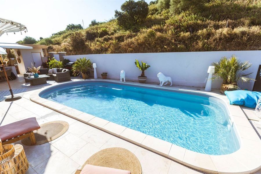 Piscine coque turquoise avec terrasse en travertin